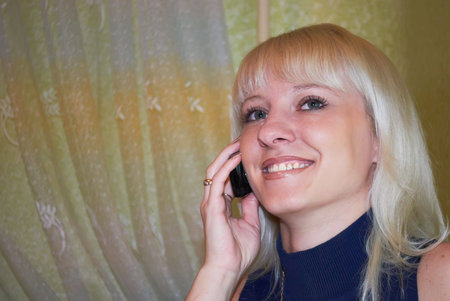 The young woman talks by a mobile phone