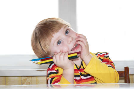 Portrait of the little boy with pencils in a handの写真素材