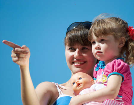 Mum With the daughter on hands on a background of the dark blue skyの写真素材