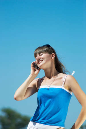 The young woman talks on mobile to phoneの写真素材