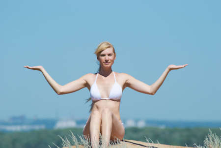 The girl in meditation on a background of the dark blue sky in the summerの写真素材