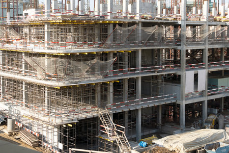 The construction of a multi-storey building. Construction iron scaffolding on several floors.