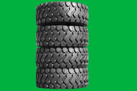 Big new tires for trucks. Car tires with a large tread are in a row. Isolated green background.の写真素材