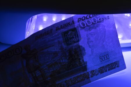 In the photo there are five thousand Russian rubles. Banknotes of Russia. Money screening equipment. Checking the bill in ultraviolet light. Fake money or financialの写真素材