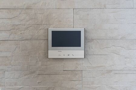The smart home system is installed in the apartment on the wall. The intercom with video surveillance of the apartment is a modern system with a large display.の写真素材