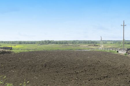 Plowed field prepared for planting. Vegetable garden in the village for potatoes, beets and other home vegetables. Spring is a sunny day.の写真素材