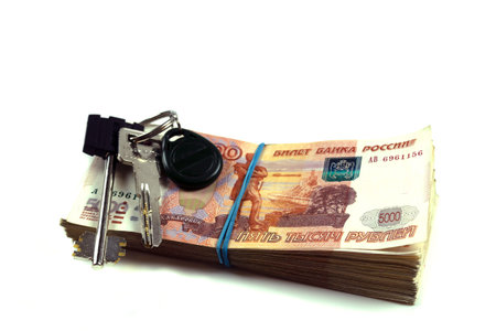 A pack of Russian rubles with a face value of five thousand rubles with the keys to the apartment. A pack of Russian money of large denominations of a million rubles. The concept of buying an apartment, mortgage, loan. On a white isolated background.の写真素材