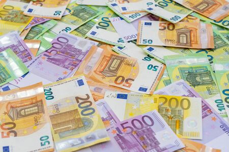 European currency lies on the table. Banknotes one hundred, two hundred, fifty, five hundred euros are scattered in a chaotic manner. Blank for design, background. Side view.の写真素材