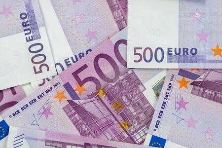 Banknotes of five hundred and 500 euros are scattered in a chaotic manner. European currency lies on the table. Blank for design, background. View from above.の写真素材