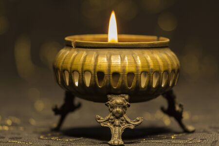 a candle flame on a dark background in the old candlestickの写真素材