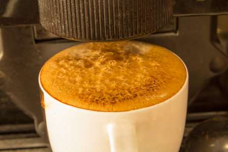 Black coffee in a white circle in the machine at home.