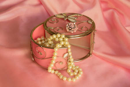 decorative box and White Pearl necklace on a pink silkの写真素材