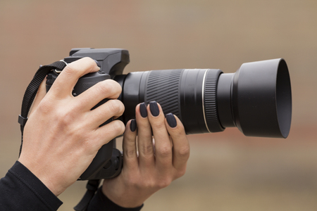 girl with beautiful manicure photographs on single-lens reflex cameraの写真素材