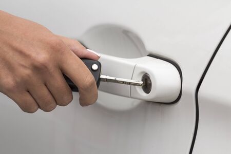 Hand opens door of white carの写真素材