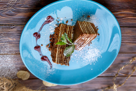 Slices of cake on a blue plate on a brown wooden background