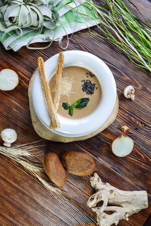 Mushroom soup with pasta with champignons and herbs on a brown wooden backgroundの写真素材