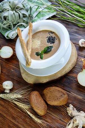 Mushroom soup with pasta with champignons and herbs on a brown wooden backgroundの写真素材