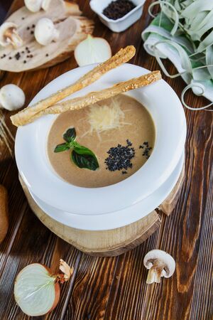 Mushroom soup with pasta with champignons and herbs on a brown wooden backgroundの写真素材