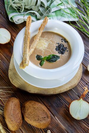 Mushroom soup with pasta with champignons and herbs on a brown wooden backgroundの写真素材