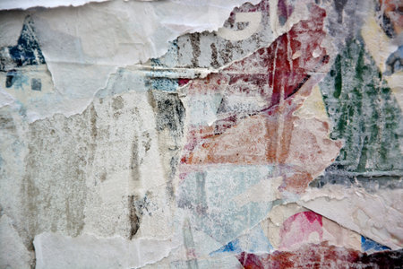 Colorful torn posters on grunge old walls as creative and abstract background