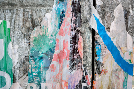 Colorful torn posters on grunge old walls as creative and abstract background