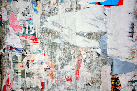 Colorful torn posters on grunge old walls as creative and abstract background