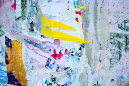 Colorful torn posters on grunge old walls as creative and abstract background