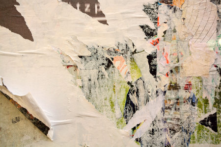 Colorful torn posters on grunge old walls as creative and abstract background