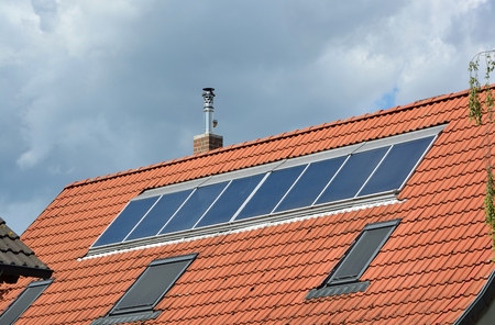 Ecological and renewable solar energy panels on the roof of a houseの写真素材