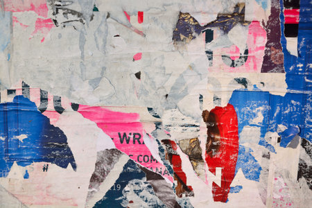 Colorful torn posters on grunge old walls as creative and abstract background