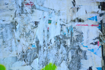 Colorful torn posters on grunge old walls as creative and abstract background