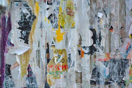 Colorful torn posters on grunge old walls as creative and abstract background