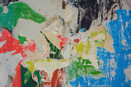 Colorful torn posters on grunge old walls as creative and abstract background