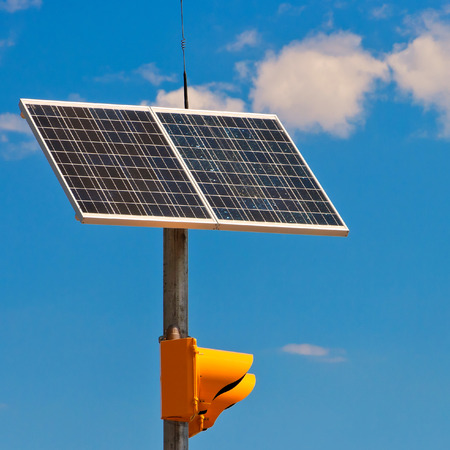 Sunny battery on a traffic-light on a background blue skyの写真素材