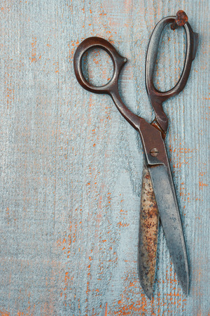 Old scissors hanging on a wooden boardの写真素材