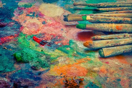 Paint brushes lie on the palette of paintsの写真素材