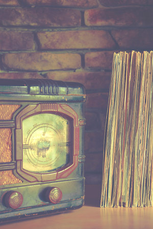 Stack of vinyl records and old players on the brick wall background