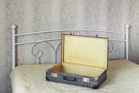 Blank open suitcase standing on a wide bedの写真素材