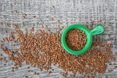 Flax seeds are scattered on the wooden boardの写真素材