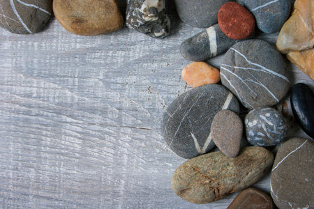 Multicolored  sea stones lie on a wooden board