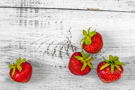 Fresh strawberries lying on the painted white tableの写真素材