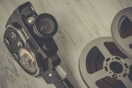 Old movie camera and film reel on the tableの写真素材