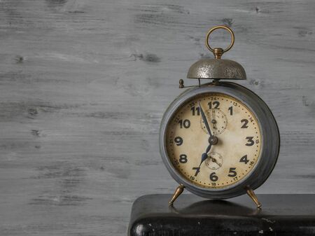 Old alarm clock on a background of wooden boardsの写真素材