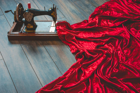 The old sewing machine with a large piece of red silk fabric