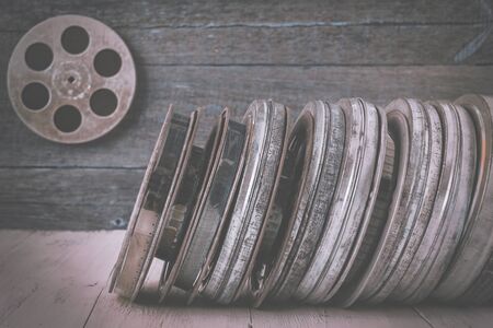 Stack of reels of old movies is on a wooden shelfの写真素材