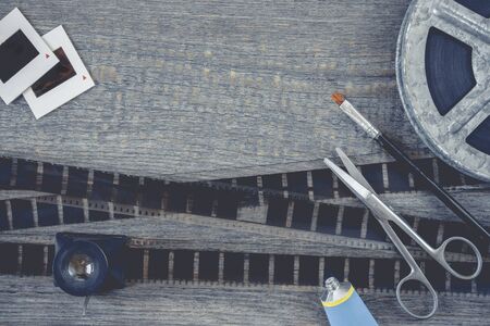 Film, scissors, glue and a brush mounting negatives lie on an old wooden tableの写真素材