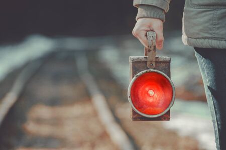 A trackman on the railway signals a red lanternの写真素材