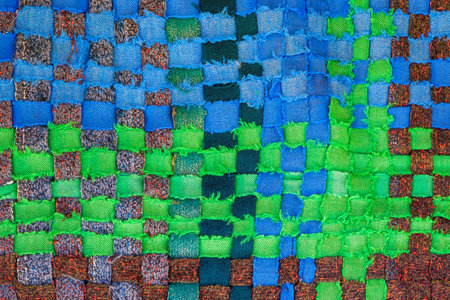 A fragment of worn hand-made fabric from multi-colored stripes