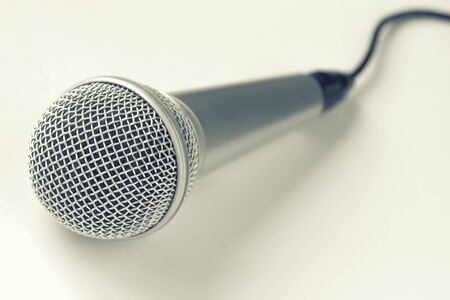 Microphone with black wire is taken close-up on a light backgroundの写真素材