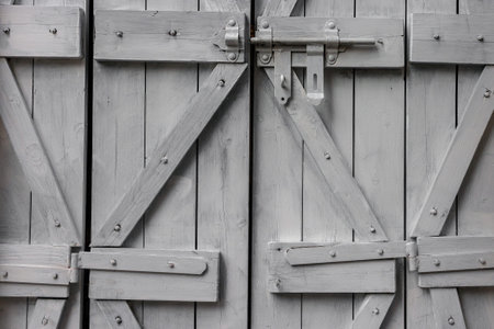 Old wooden shutters with metal bolts closed the window of the house